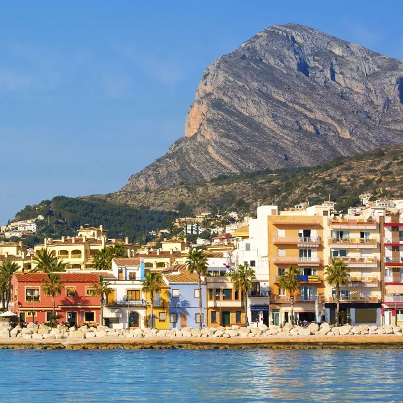 Colourful seafront buildings at Jávea port, with Montgó mountain behind